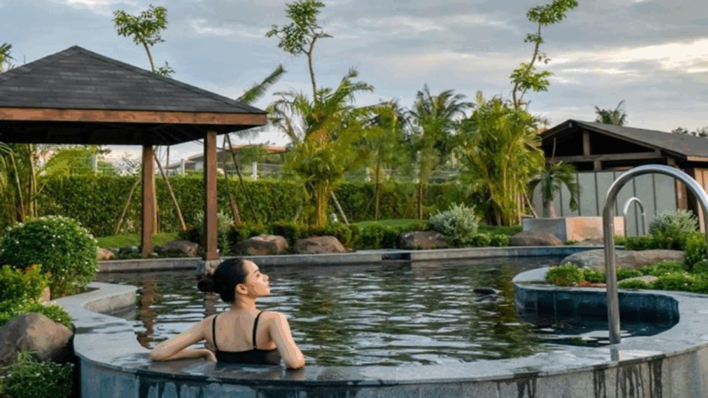 Một phụ nữ thư giãn trong hồ khoáng nóng ngoài trời tại Minera Hot Springs Bình Châu, đậm phong cách Onsen truyền thống giữa thiên nhiên miền Nam Việt Nam.